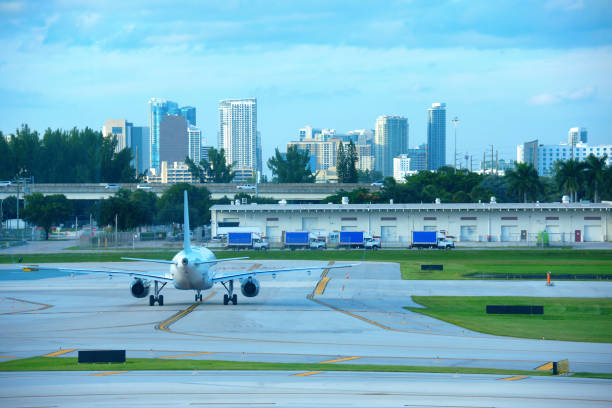 Commercial jet airliner airplane on the tarmac at international airport with Fort Lauderdale skyline in background stock photo