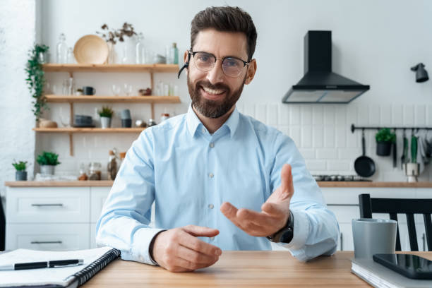 istock Smiling businessman webinar speaker in headset looking at camera webcam view 1351983315