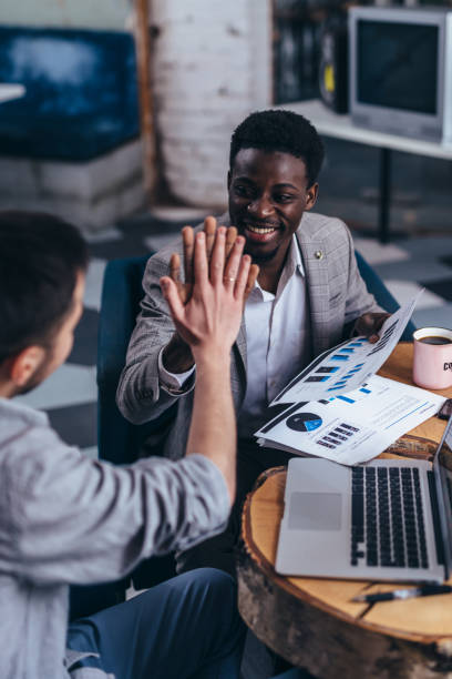 istock Business partners giving high five at table. 1351988380