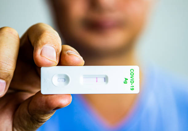 istock Man is showing result of  coronavirus(covid-19) rapid antigen self test kit 1351989272