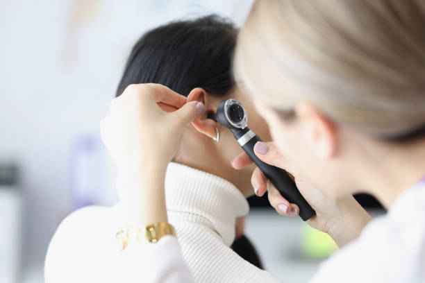 ENT doctor examining patient Close-up of female otolaryngologist examining ear with otoscope. Patient with earache at doctor appointment. Otolaryngology, medicine and healthcare concept hearing test stock pictures, royalty-free photos & images