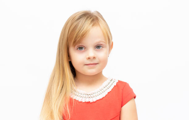 beau portrait d’une petite fille de 4-5 ans, sourire amusant. enfant fille posant en studio en se tenant la main en l’un, le jeune mannequin porte une robe rouge et une coiffure en queue de cheval - 4 5 years photos et images de collection