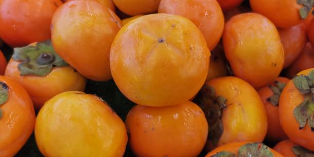 istock Ripe fresh persimmons in the market 1351993915