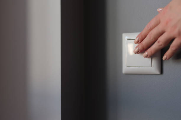 istock Hands push the switch on the wall, close-up 1351996431