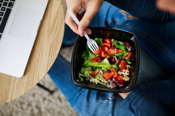 istock Man enjoying a healthy takeaway salad on a lunch break 1351997580