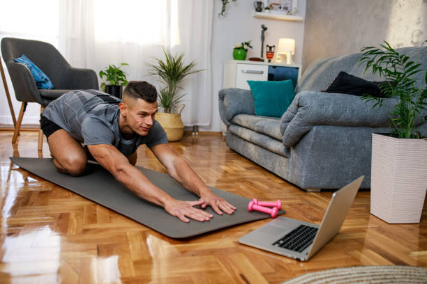 istock Young man doing stretching exercises on a video call with a client 1351997688