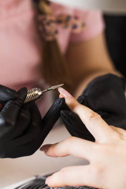 istock A manicurist removes gel polish from nails using a milling cutter. Hardware manicure close-up. Coating shellac on nails 1351998094