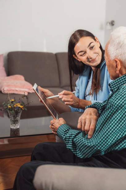 istock Caregiver examining a senior man at home 1352000095