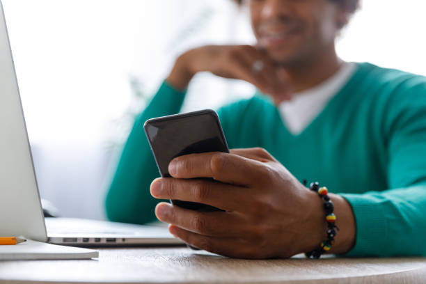 istock Male entrepreneur reading text messages on smart phone while working 1352000977