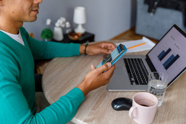 istock Man managing home finances via smart phone app 1352001116