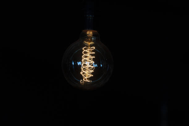 istock Lamp light bulb detail isolated on black 1352006619