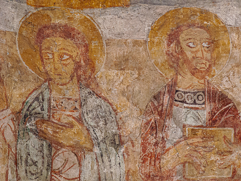 St John the evangelist as a young man without a beard and st Paul with a book, romanesque painting from the 1100s in Övraby church, Sweden, November 6, 2009