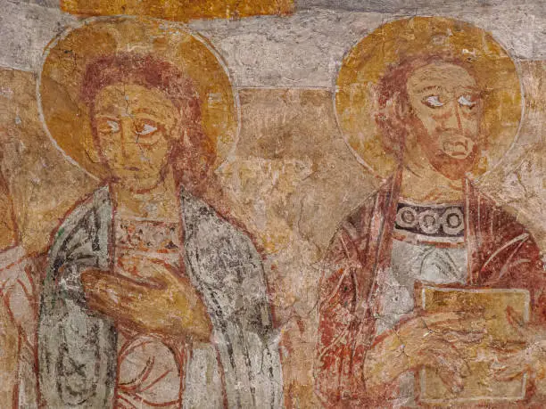 St John the evangelist as a young man without a beard and st Paul with a book, romanesque painting from the 1100s in Övraby church, Sweden, November 6, 2009