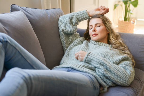 istock attractive middle aged woman on the couch 1352008129