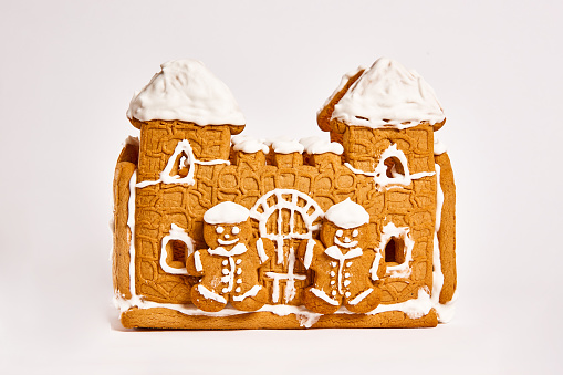 gingerbread house with icing decor on white background