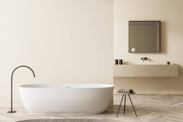 istock Beige bathroom with oval white bathtub and square mirror 1352010613