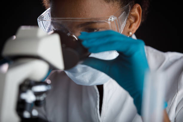 istock Close up shot of female scientist analyzing a sample under a microscope 1352010784