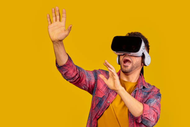 istock Surprised young guy in VR glasses on a yellow background, man use virtual reality glasses, copy space 1352013441