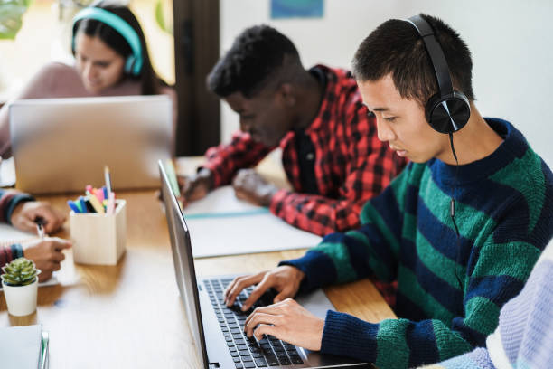 istock Multiracial students studying together at library - Focus on asian boy headphones 1352014297