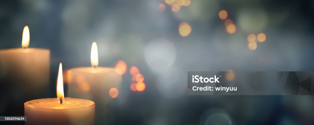 closeup of 3 burning candles on abstract black background, contemplate celebration mood with blurry lights, festive concept with copy space Candle Stock Photo