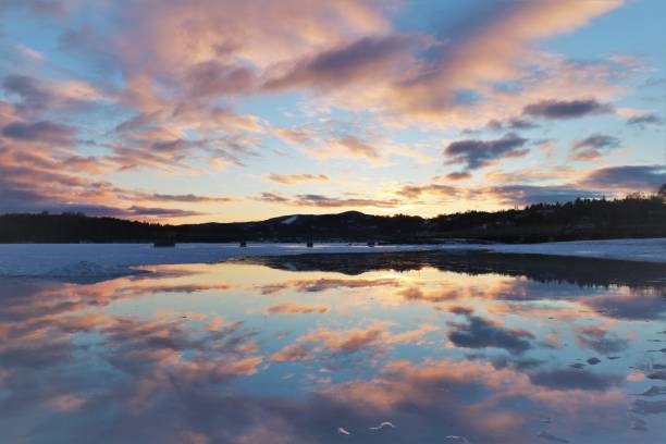 ciel norvégien au coucher du soleil sur un fjord semi gelé - frozen ice sky sun photos et images de collection