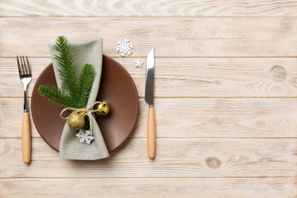 istock Christmas table place setting with christmas decor and plates, kine, fork and spoon. Christmas holiday background. Top view with copy space 1352015101