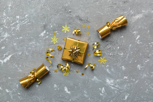 istock Christmas crackers with shiny confetti on color background, top view, copy space 1352015191