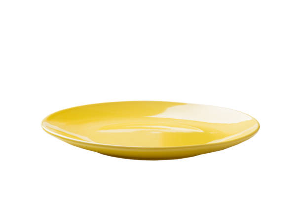 Yellow ceramic round plate isolated over white background. perspective view.