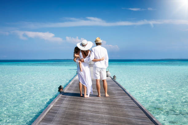 rodzina w białych letnich ubraniach stoi na molo na malediwach - beach two parent family couple family zdjęcia i obrazy z banku zdjęć