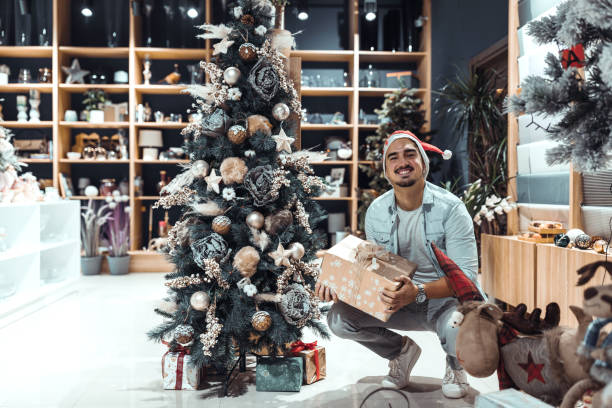 istock Smiling  young man in Santa hat with gift boxes. 1352016543