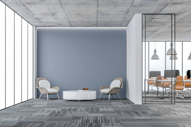 istock Empty office interior: a lounge corner with copy space and wordesks behind glass door 1352019403