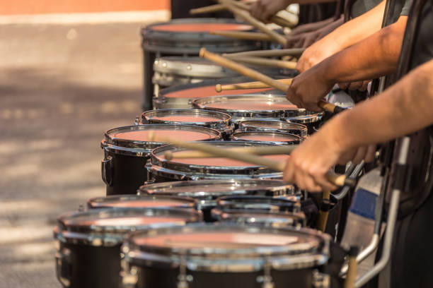 abschnitt einer marching band drum line, die sich für eine parade aufwärmt - stahlfass stock-fotos und bilder