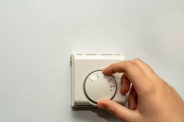 istock regulating a thermostat to a temperature to save heating and control gas consumption in the face of the energy crisis 1352021748