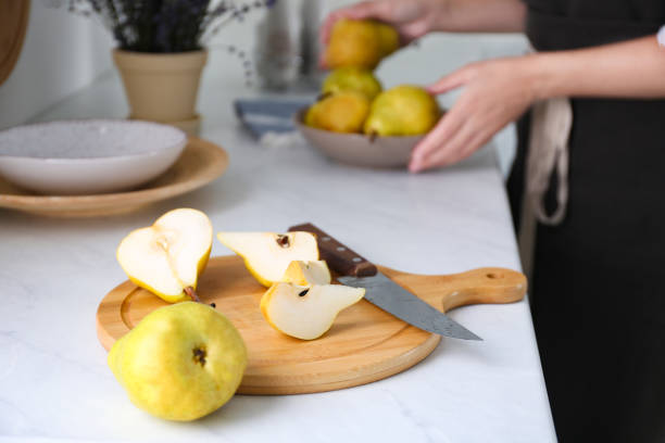 Fresh cut and whole pear on white countertop in kitchen