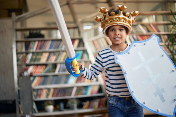 istock A cheerful little boy with a sword and a shield is posing for a photo while playing at home. Family, home, playtime 1352023392