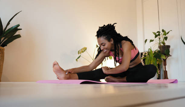 istock Attractive and healthy young black woman doing exercises while resting at home 1352023702