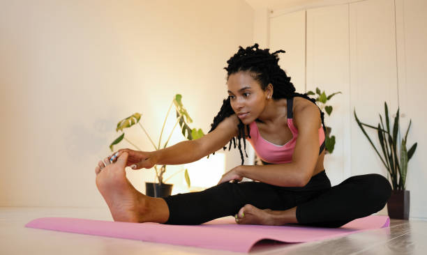 istock Attractive and healthy young black woman doing exercises while resting at home 1352023703