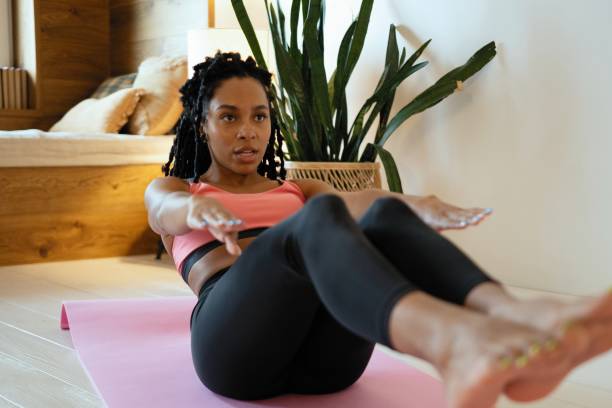 istock Attractive female doing exercise in her living room. She doing abs. Workout. 1352023725