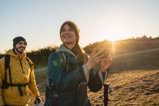 fröhliche frau, kann ihre freude an der majestätischen natur während ihrer wanderung mit einem freund nicht verbergen - telephone nature mobile phone autumn stock-fotos und bilder