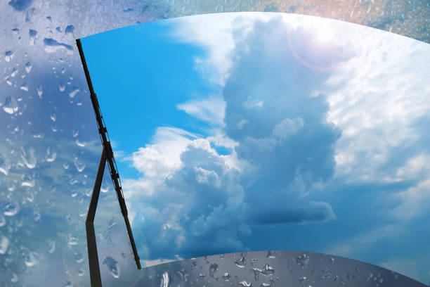 istock Car windshield wiper cleaning water drops from glass 1352032100