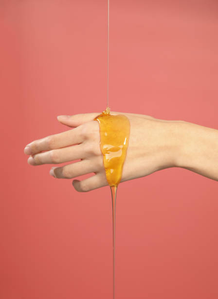 istock honey flowing on female hand 1352034303