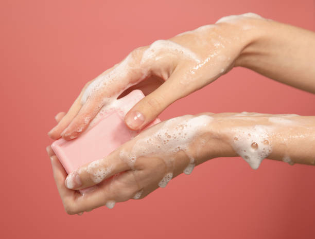 istock hands using pink soap bar in foam isolated on pink background 1352034321