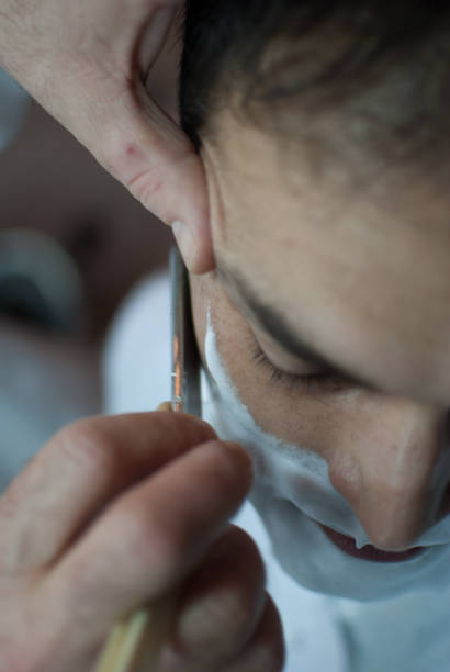 istock Adult man taking a shave at the barber 1352036706