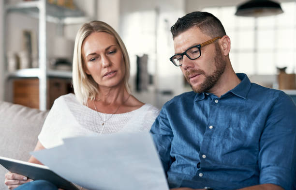 istock Shot of a couple sitting in their lounge reviewing bills while using a digital tablet 1352036745