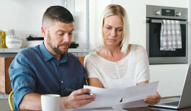 istock Shot of a couple going through their bills while using their laptop in the kitchen 1352036817