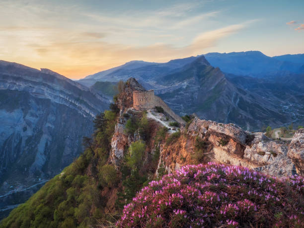 increíble amanecer en la antigua fortaleza en la cima de la montaña. la fortaleza de gunib es un monumento histórico de daguestán. rusia. - mountain mountain peak environment caucasus fotografías e imágenes de stock