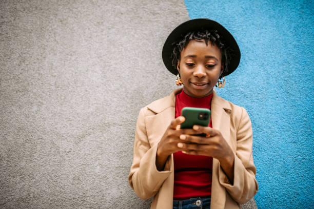 istock Young stylish black woman posing on a wall background 1352037791