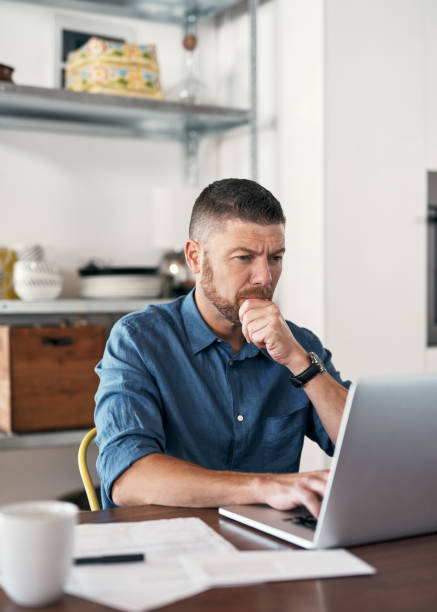 Shot of a businessman working from home using his laptop