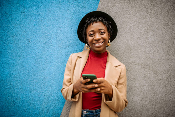 istock Young stylish black woman posing on a wall background 1352037927
