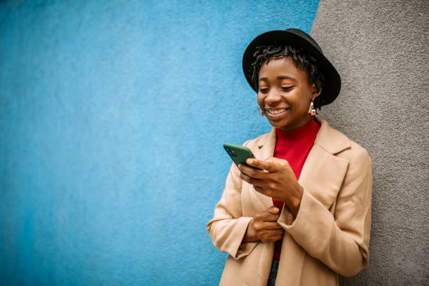 istock Young stylish black woman posing on a wall background 1352038117